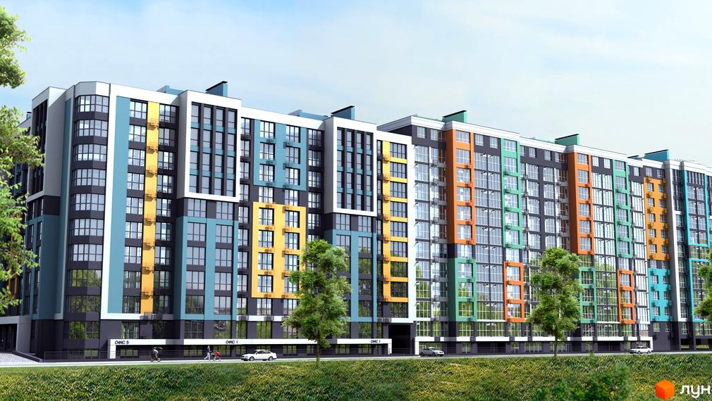 Багатоповерховий будинок житлового комплексу Олександрівський з різнокольоровими фасадами. Поруч з будинком зелена трава та дерева.