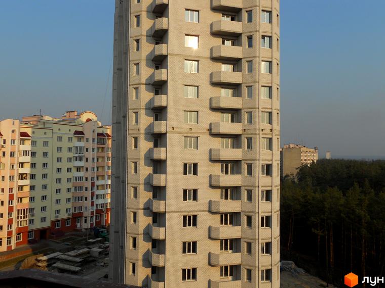 Житловий комплекс Чисті сосни з сучасними балконами та прибудинковою територією, оточений зеленими насадженнями.