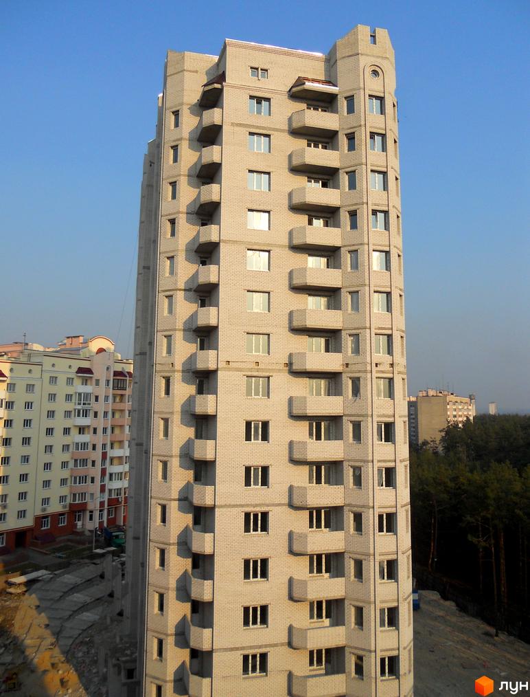 Житловий комплекс Чисті сосни, висотна будівля з балконами та великими вікнами. Прибудинкова територія з зеленими насадженнями та облаштованими доріжками.