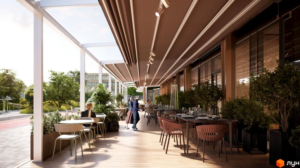 Тераса ресторану житлового комплексу Creator City з дерев'яною підлогою та меблями. Навколо зелені насадження та вид на будівлі.