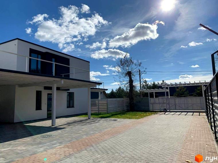 Котеджне містечко КМ Wood Side Village. Зовнішній вигляд двоповерхових будинків з навісами для авто та вимощеною територією.