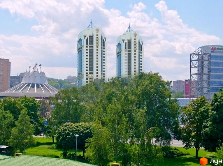Житловий комплекс Континент з двома висотними будинками на фоні зелених насаджень та облаштованої території.