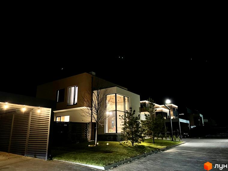 Зображення сторінки ЖК Crystal Forest. На фото зображені будинки з великими вікнами та освітленням на території.