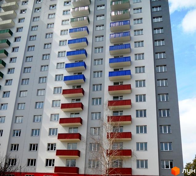 Житловий комплекс Райдужний з кольоровими балконами та сучасними вікнами. Прибудинкова територія озеленена деревами.