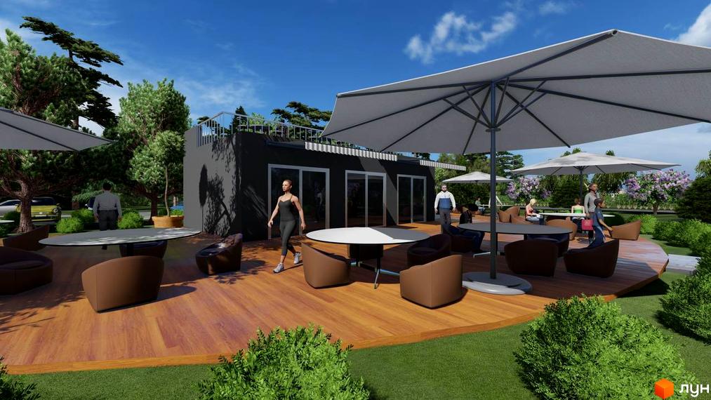 Зовнішній вигляд КМ BY THE RIVER з терасою та парасолями, що запрошує до відпочинку на свіжому повітрі серед зелені. Прибудинкова територія з місцями для сидіння та столиками створює затишну атмосферу.