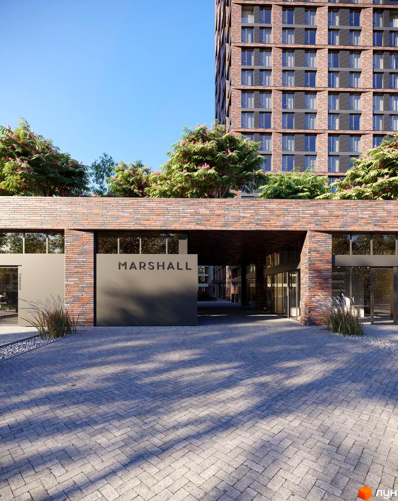 Житловий комплекс MARSHALL з цегляним фасадом та під'їздом, вимощеним бруківкою. Навколо зелені дерева та кущі.