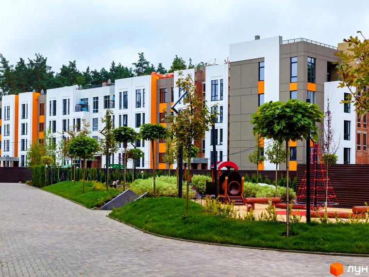 Зображення Житлового комплексу Найкращий квартал: багатоповерховий будинок з дитячим майданчиком на прибудинковій території. Вигляд фасаду та ландшафтного дизайну.