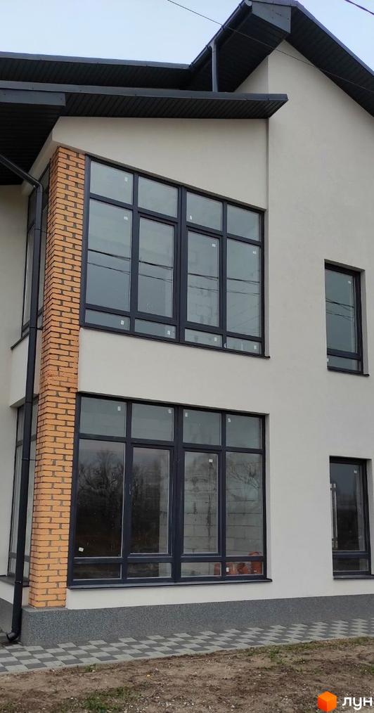 Будівельний проєкт Лелека: фасади будівель з великими вікнами та цегляними елементами, прибудинкова територія з бруківкою.