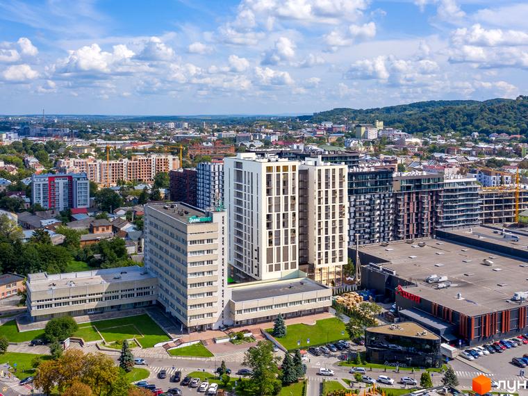 WELL towers – апарт-комплекс з білими фасадами та скляними балконами, розташований поруч із зеленим парком та торговим центром.