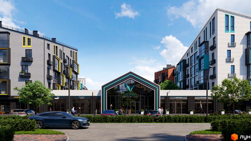 Зовнішній вигляд новобудови ЖК Verba з магазинами на першому поверсі та автомобілями на парковці. Прибудинкова територія з деревами та кущами.