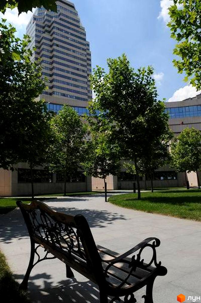 Житловий комплекс Амфітеатр з висотним будинком на фоні. Прибудинкова територія з зеленими насадженнями та пішохідними доріжками.