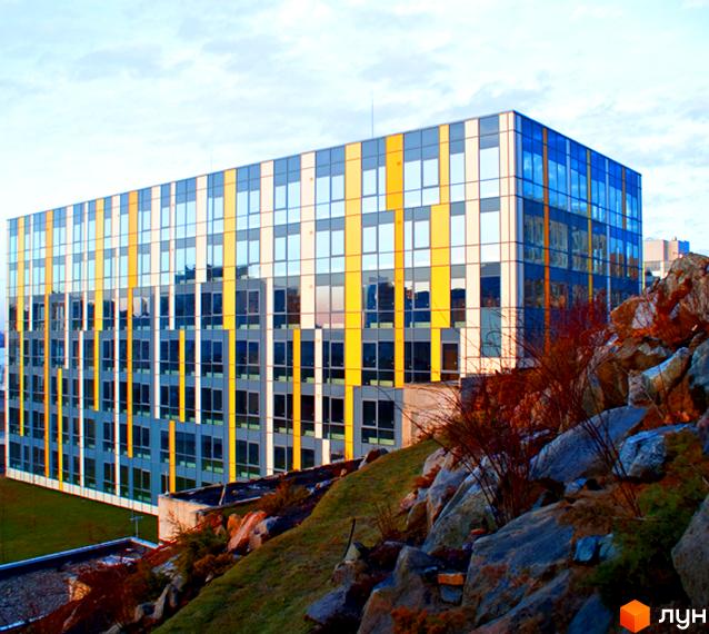 Житловий комплекс Фестивальний з яскравими фасадами та великими вікнами. Прибудинкова територія з зеленими насадженнями та кам'яними елементами.