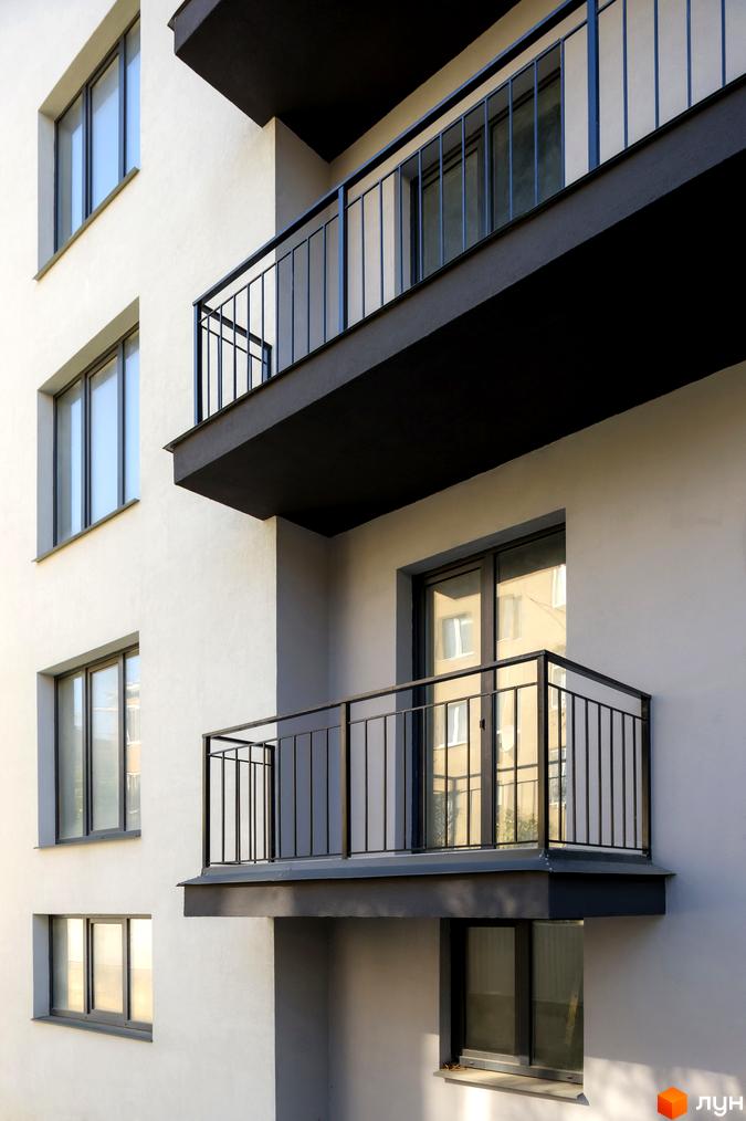 Фасад житлового комплексу на вулиці Козачука, 27а, з балконами та вікнами. Зовнішній вигляд новобудови.