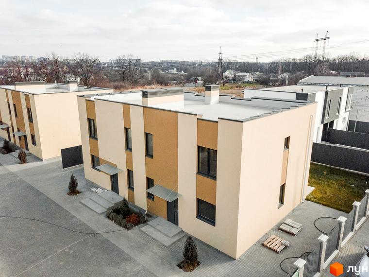 Котеджне містечко КМ My Land: двоповерхові будинки з пласкими дахами та комбінованим оздобленням фасадів, розташовані на вимощеній прибудинковій території з зеленими насадженнями.