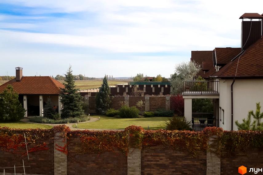 Котеджне містечко КМ Барвіта. Зовнішній вигляд будинків та прибудинкова територія з газоном і деревами.