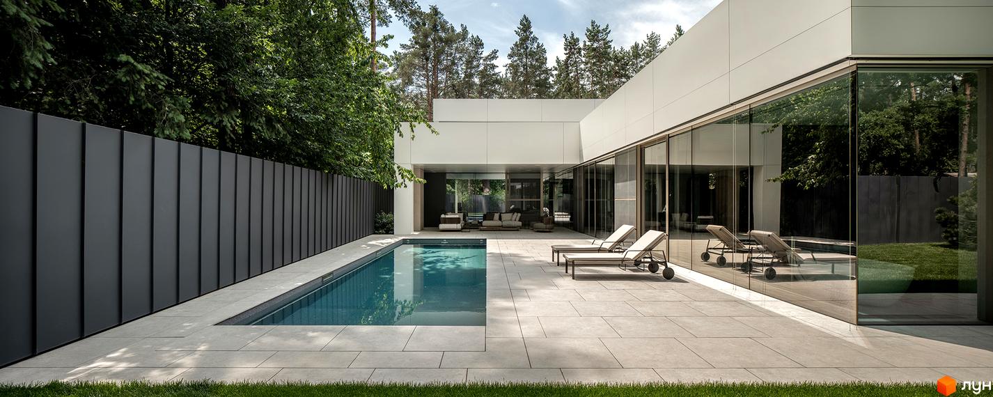 Білий будинок Котеджного містечка 3L Residences з панорамними вікнами, басейном, світлою терасою та темним парканом.