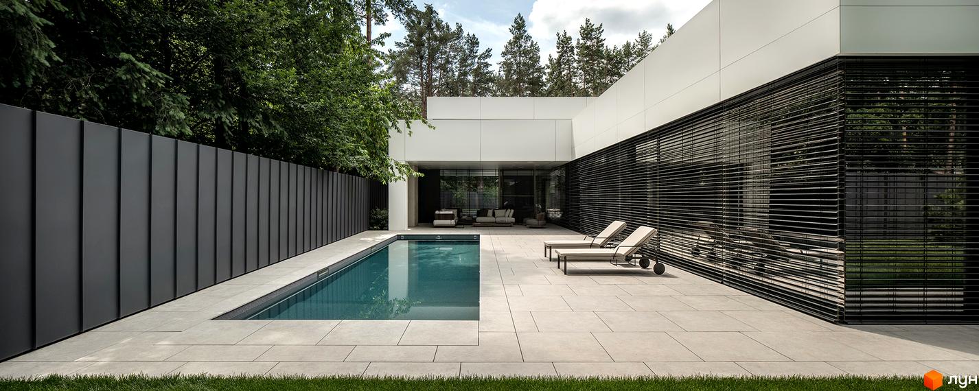 Білий фасад будинку з горизонтальними жалюзі та прямокутний басейн на подвір'ї Котеджного містечка 3L Residences.