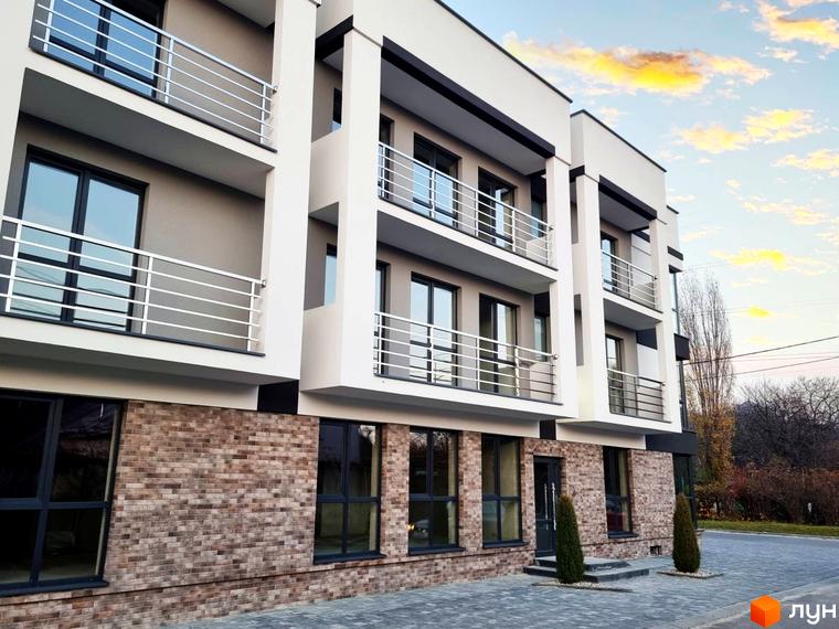 Зображення фасаду Житлового комплексу Преміум Хаус з балконами та панорамними вікнами. На передньому плані озеленена територія.