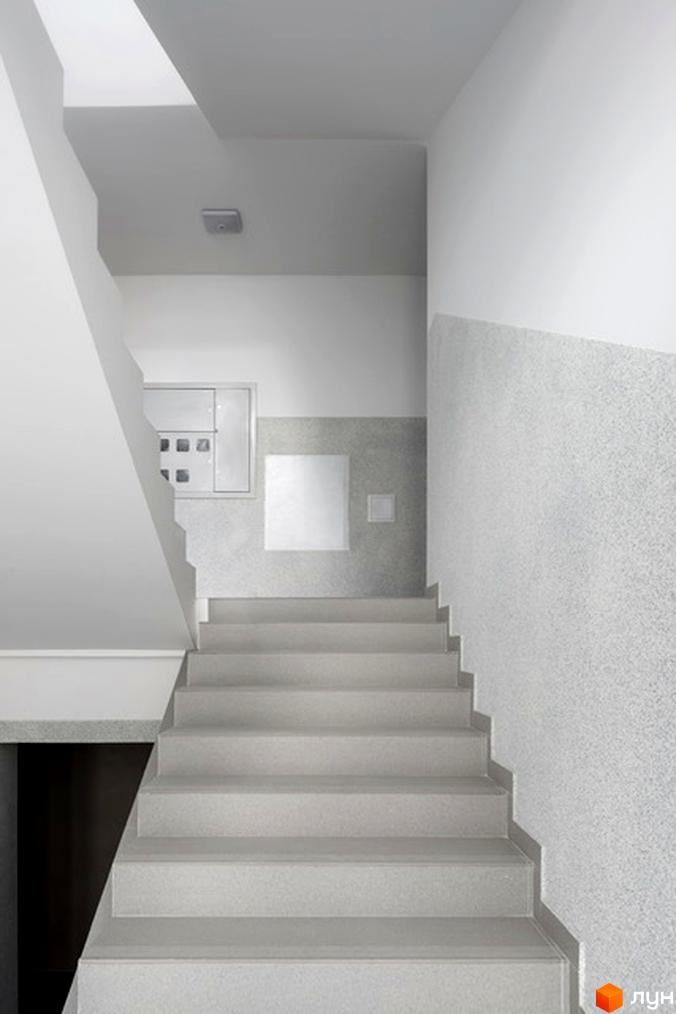 Фото сходової клітки в новобудові на вул. Козачука, 27а. Чисті та світлі сходи ведуть на верхні поверхи будинку.