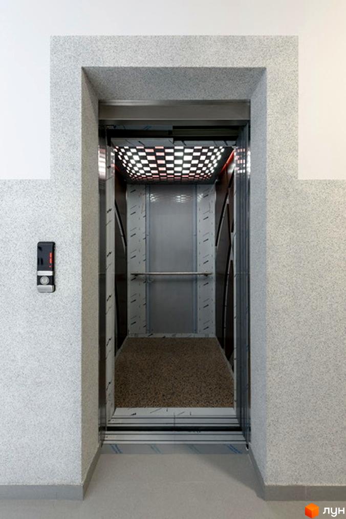 Сучасний ліфт у новобудові на вулиці Козачука, 27а. Всередині ліфта – металеві стіни та підлога з килимовим покриттям.
