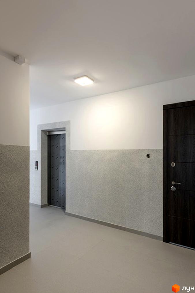 Під'їзд житлового комплексу на вулиці Козачука, 27а. Відкритий ліфт та двері в коридорі.