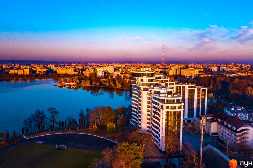 Житловий комплекс Parus з висоти пташиного польоту. Видно багатоповерхівки з білими балконами, поруч озеро, футбольне поле та міська забудова.