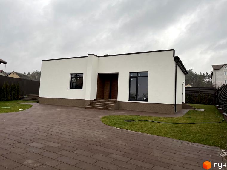 Котеджне містечко White Stone: одноповерховий будинок з білою штукатуркою та темними вікнами, вимощена доріжка та зелена галявина.