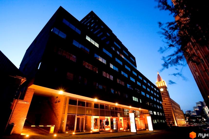 Житловий комплекс БФК „Дом на Катеринославском“ з сучасним фасадом та прибудинковою територією в вечірньому освітленні.