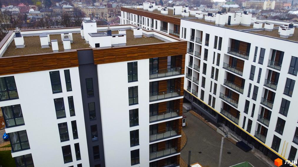 Високоповерхові будинки ЖК Globus Central Park з білими фасадами та панорамним склінням. На території комплексу передбачено озеленення та місця для відпочинку.