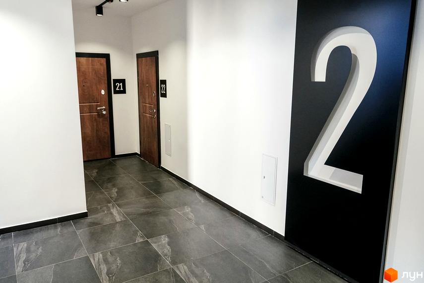 Коридор у новобудові ЖК Globus Central Park з дверима квартир та великою цифрою 2 на стіні.