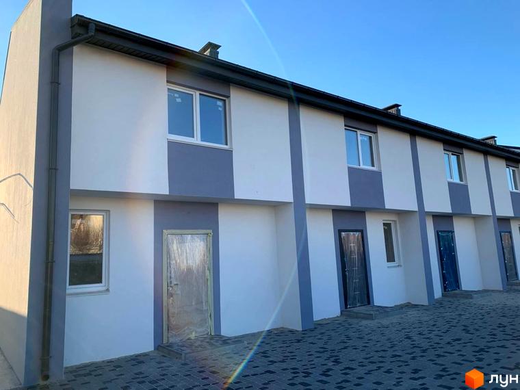 Зовнішній вигляд таунхаусів Smart Country House 2. Двоповерхові будинки з сірими вставками та вікнами, перед будинками вимощена бруківка.