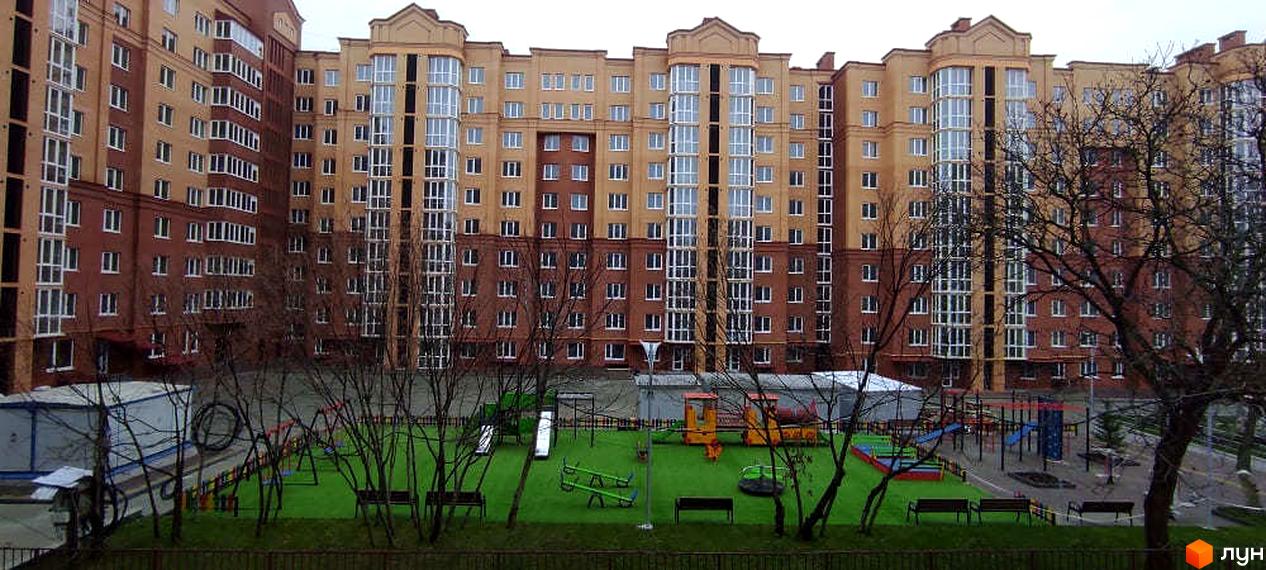 Зображення фасаду будинку на вулиці Київській. На території Житлового комплексу дитячий майданчик з гойдалками та гірками.