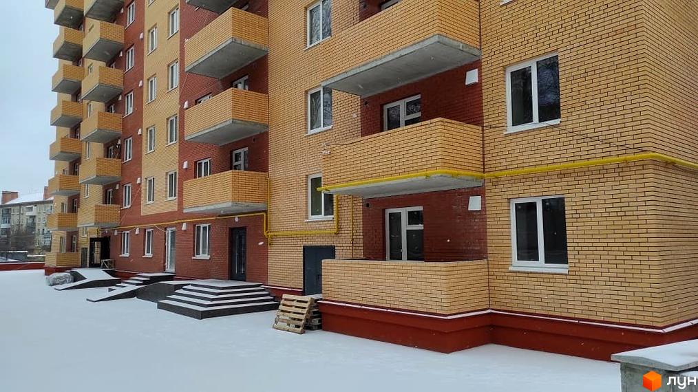 Зовнішній вигляд багатоповерхового будинку ЖК по вул. Миру, 6а з балконами та сходами, вкритими снігом. Видно прибудинкову територію.