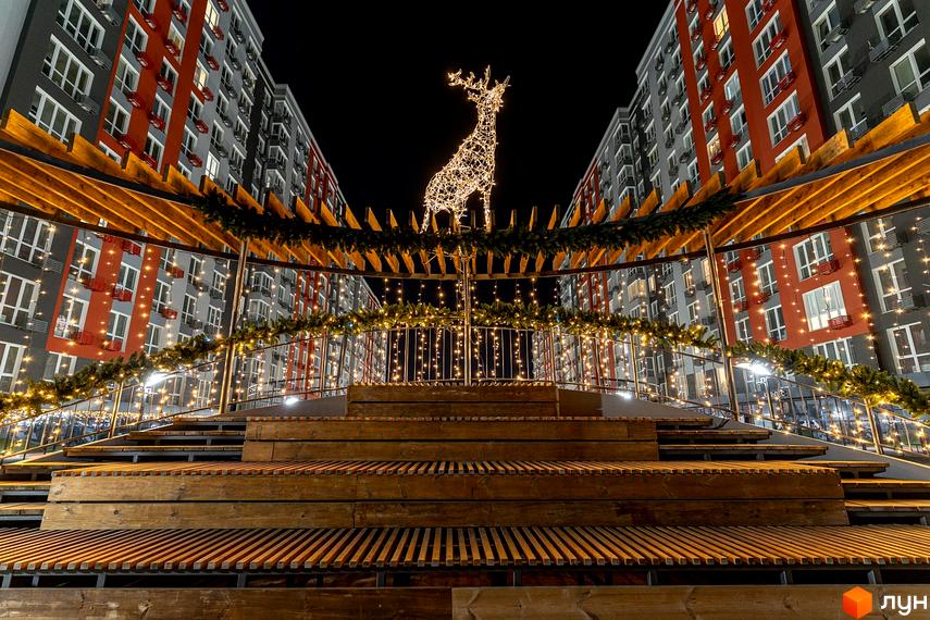 Житлове містечко ARTVILLE з новорічною ілюмінацією. Зовнішній вигляд будинків та прибудинкова територія з ялинковими гірляндами та оленем з гірлянд.