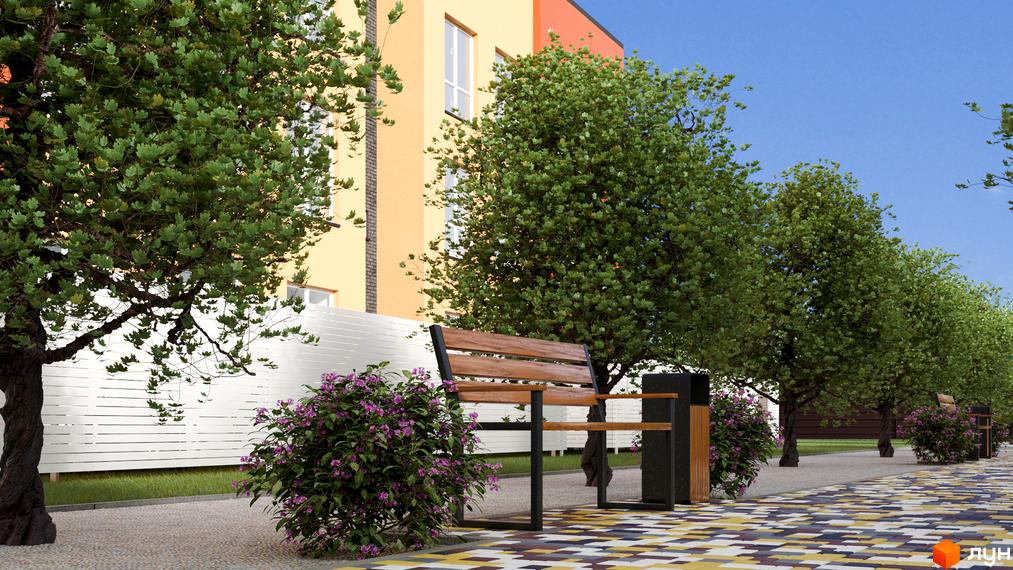 Житловий комплекс Калиновий Квартал з фасадом в теплих тонах, лавкою та зеленими насадженнями на прибудинковій території. Бруківка на тротуарі.