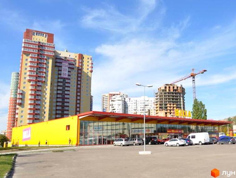 Житловий комплекс Тріумф з висотними будинками та прибудинковою територією, на фоні жовтого магазину.