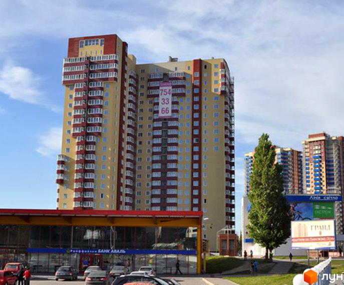 Житловий комплекс Тріумф з яскравими фасадами та балконами. Прибудинкова територія з паркувальними місцями та зеленими насадженнями.