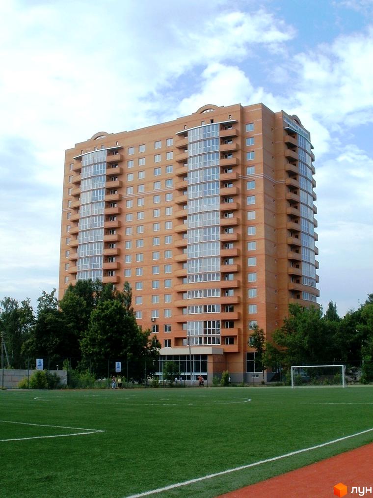 Житловий комплекс Молодіжний з сучасним фасадом та балконами. Прибудинкова територія з футбольним полем та зеленими насадженнями.