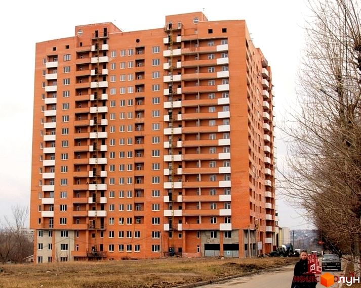 Будинок житлового комплексу ЖК Гранд з червоної цегли, прибудинкова територія з зеленими насадженнями та пішохідною доріжкою.