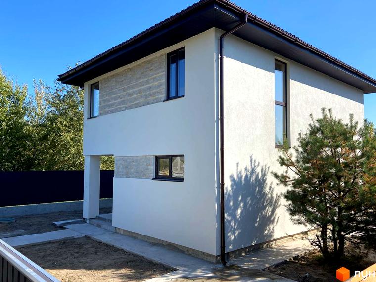 Зовнішній вигляд двоповерхового будинку в Котеджному містечку Vita House. Навколо будинку зелені насадження та частково облаштована територія.