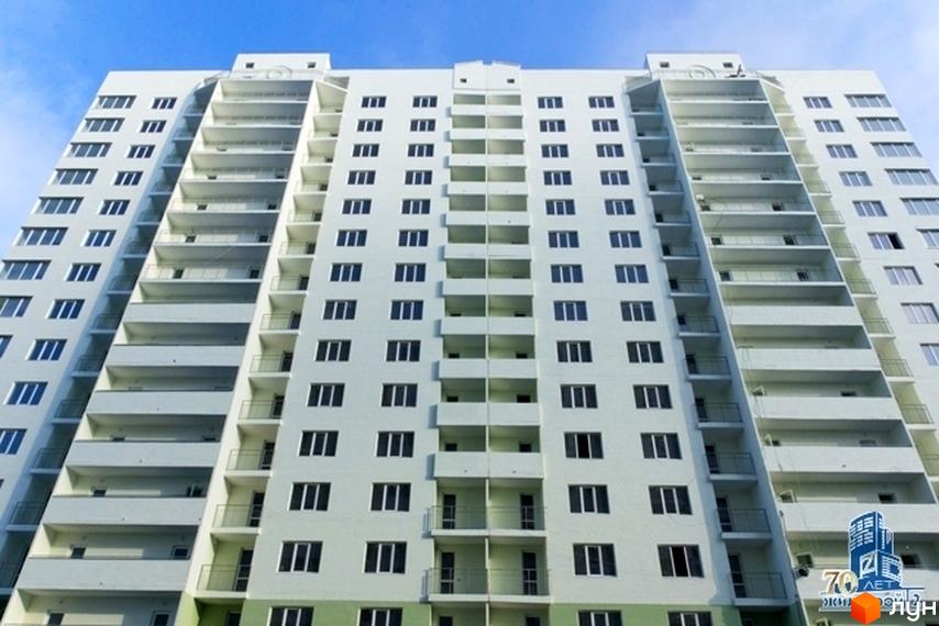 Житловий комплекс Квартет, фасад будинку з балконами та великими вікнами, чисте небо на фоні.