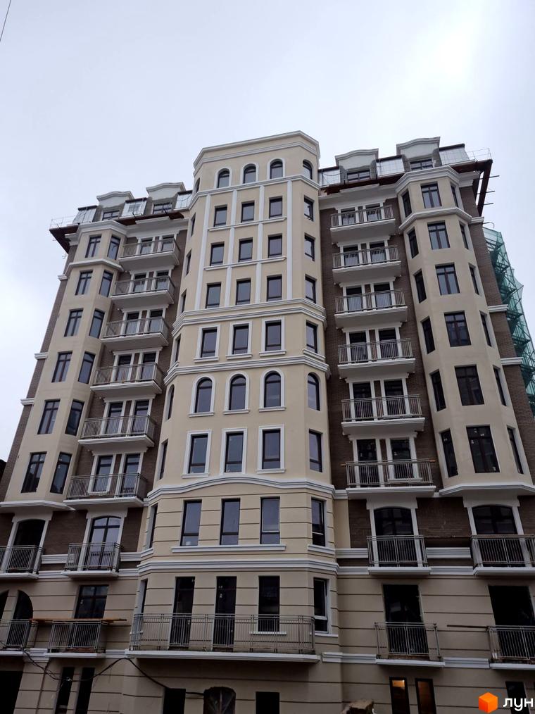 Фасад житлового комплексу Віндзор з численними балконами та вікнами. Будинок має багатоповерхову структуру з виразною архітектурою.