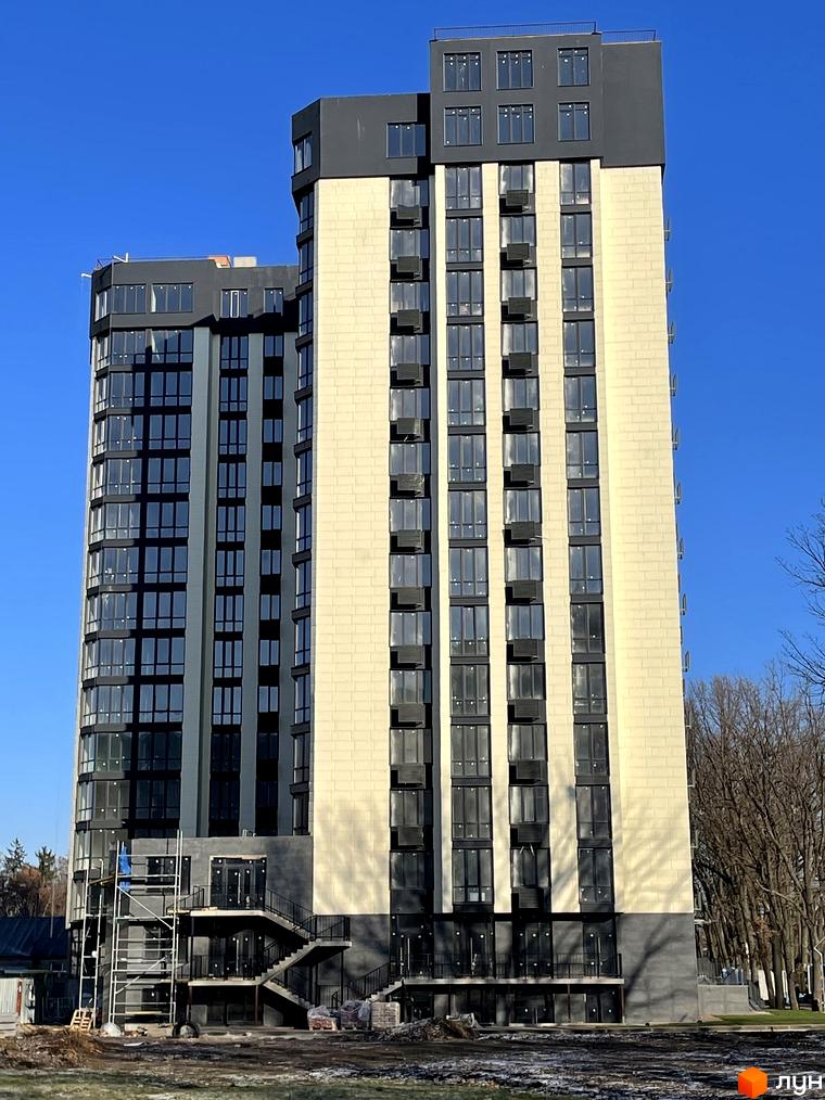 Житловий комплекс Park Plaza: високі будинки з бежевим фасадом та темними вікнами. Навколо видно будівельний майданчик та дерева.