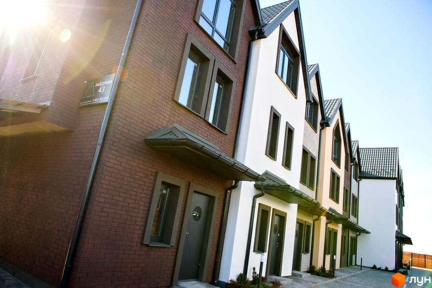 Зовнішній вигляд таунхаусів New Smart X. Фасади будинків оздоблені цеглою та білою штукатуркою, дах з металочерепиці.