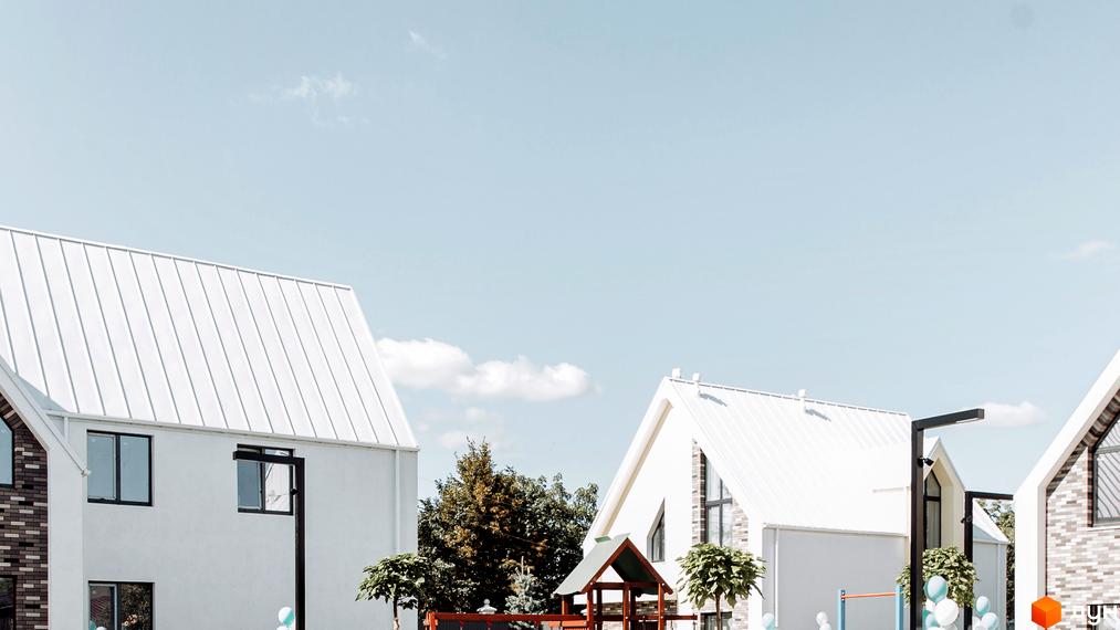 Білі будинки Котеджного містечка Solo Home з контрастними вікнами та металевими дахами. На території розташований дитячий майданчик та зелені насадження.