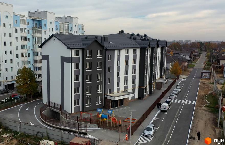 Житловий комплекс Антрацит - це сучасна новобудова з сіро-білим фасадом та дитячим майданчиком на прибудинковій території.