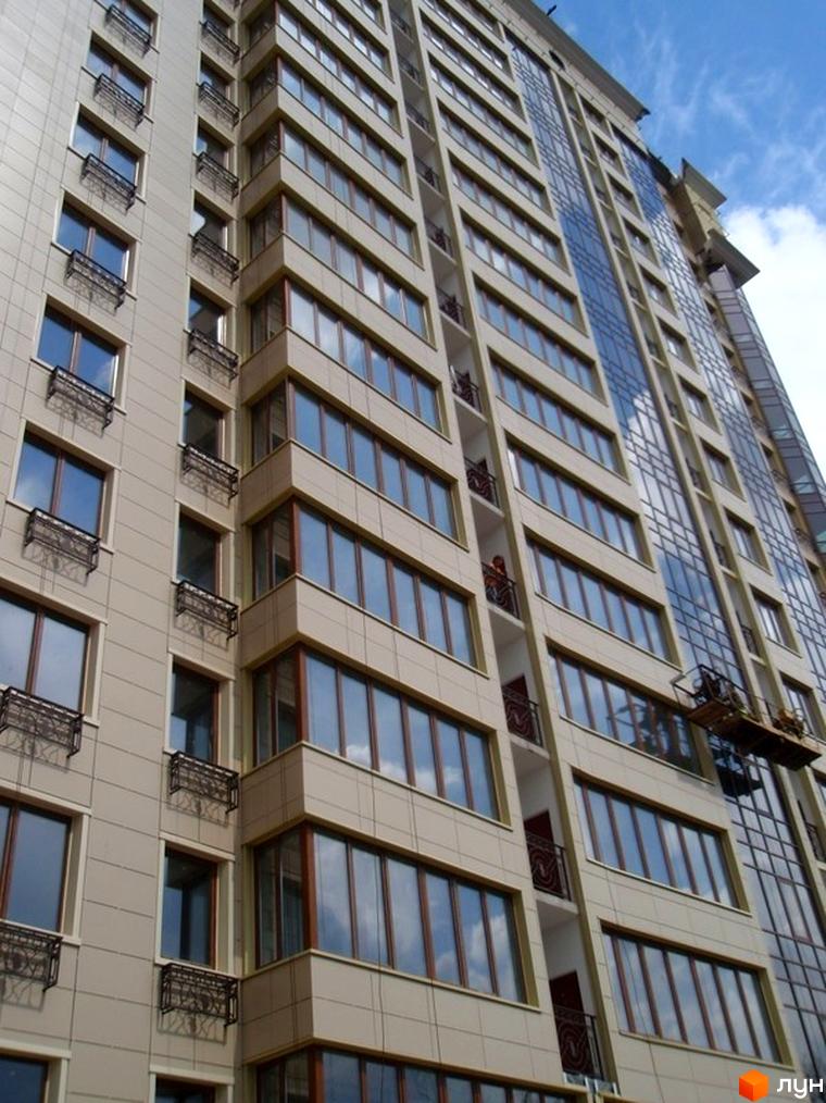 Житловий комплекс Дом в Сокольниках з фасадом з великими вікнами та балконами. Прибудинкова територія озеленена та облаштована.