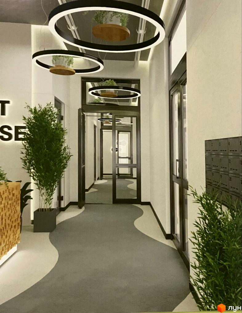 Інтер'єрний коридор Житлового комплексу ART HOUSE з оригінальними круглими світильниками, зеленими рослинами та хвилястим дизайном підлоги.