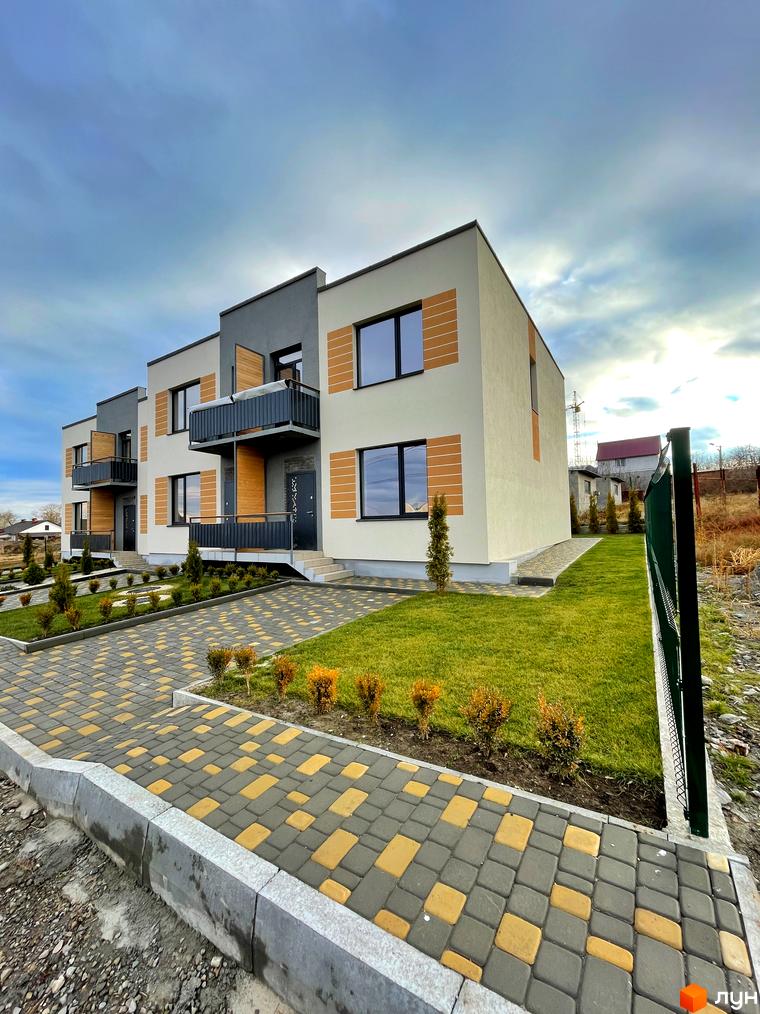 Зовнішній вигляд таунхаусів Twin House з балконами. Прибудинкова територія з газоном та доріжками з тротуарної плитки.