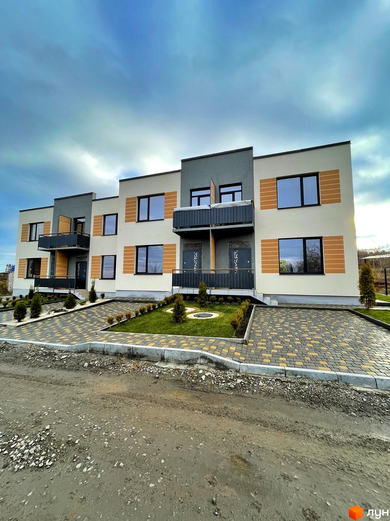 Зовнішній вигляд таунхаусів Twin House з балконами. На території ландшафтний дизайн з газоном та доріжками з тротуарної плитки.